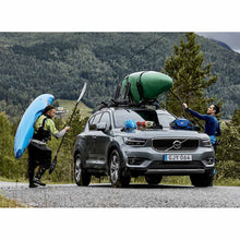 Load image into Gallery viewer, Paddlers loading kayaks onto the Thule Hull-a-Port XTR
